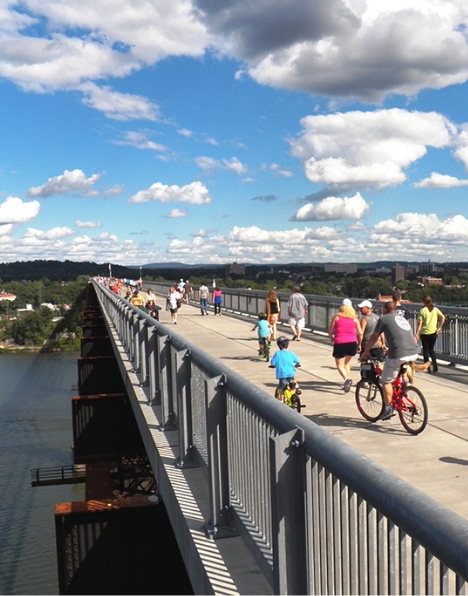 People enjoying the view on bikes and walking over the Walkway over the Hudson